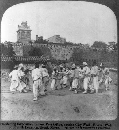 photo of several men lifting a wall upright with ropes