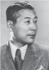Alt text for the portrait: A portrait of Sugihara Chiune, a middle-aged man, dressed in a Western-style suit and tie. The image captures his professional appearance, reflecting his role and presence in a formal setting.