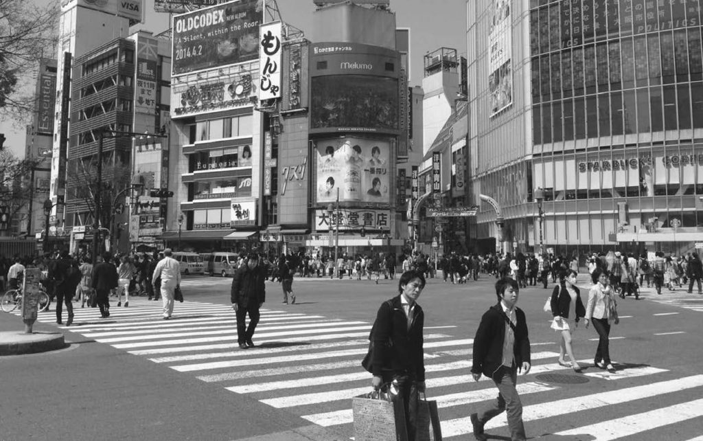 A photograph of a crowded Shibuya crossing in Tokyo. Shibuya crossing is the busiest intersection in the world. 
