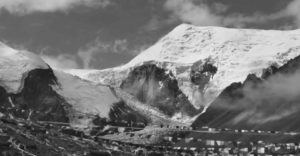 Photo of mountains with multiple long strings of miniature prayer flags strung across in front. 