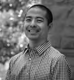 Photograph of Rylan Sekiguchi a middle aged Asian man wearing a striped shirt and smiling happily.