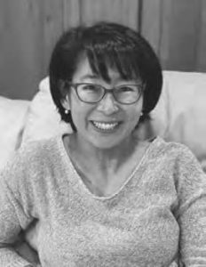 photograph of a woman wearing glasses smiling 
