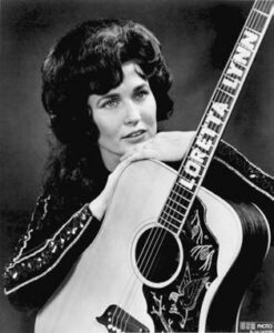 black and white photo of a woman with a guitar