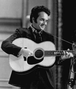 black and white photo of a man holding a guitar