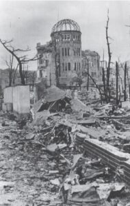 photo of a dilapidated and destroyed building with a dome, sitting among ruins and dead trees