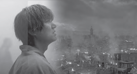 black and white photo of a young man walking among firey ruins