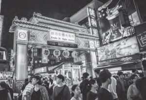 photo of a busy market street with a giant lit up gate with roahe st. night market