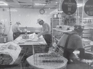 photo of several people preparing food in a kitchen