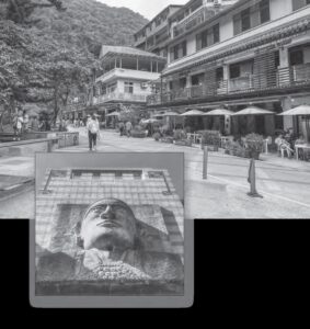 photo of a carved face in a wall and a street with several apartments