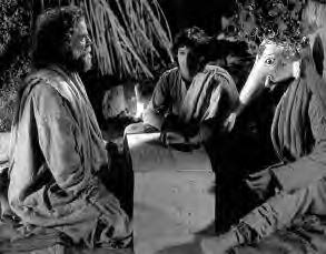 two men speak with a man with an elephant head