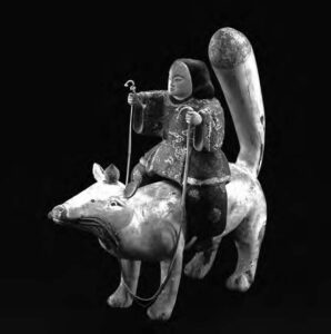 a painted figurine of a person riding an animal