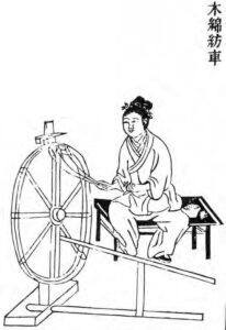 a woman spins cotton on a spinning wheel