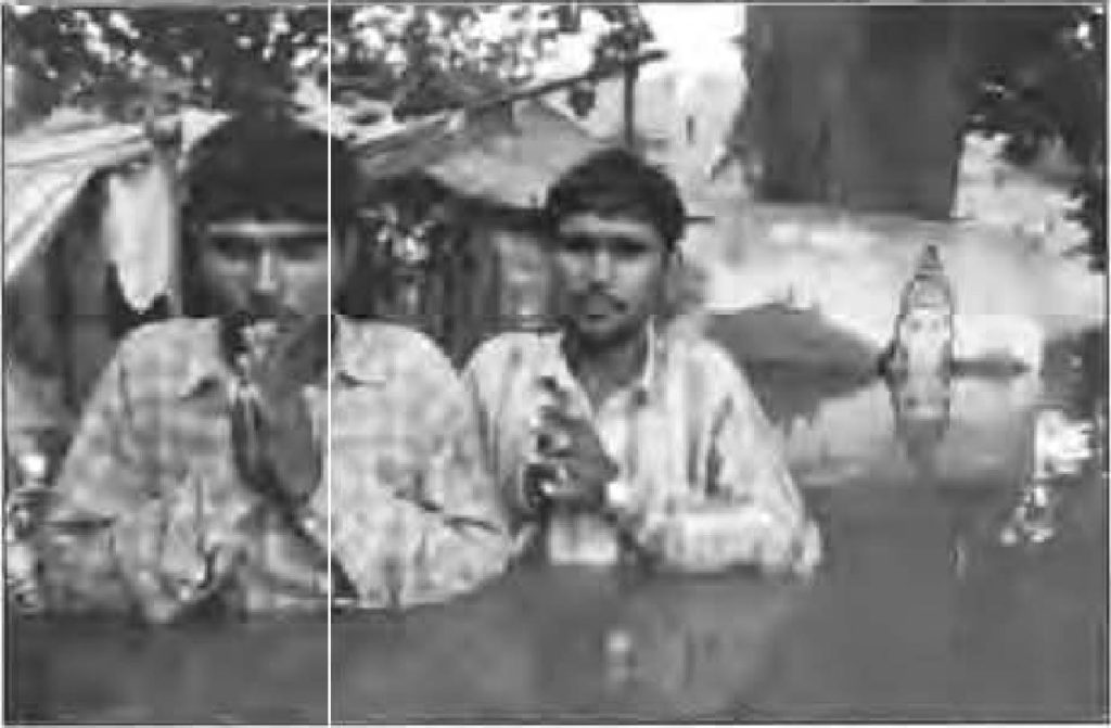 photo of two men standing in chest-high water. They clasp their hands together in prayer