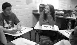 a photo of two teens sitting as a part of a circular group, speaking