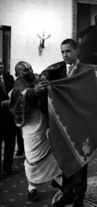 an image of a hindu priest putting a shawl over a man (president of the united states)